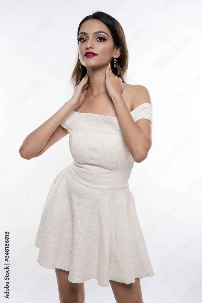 Young Indian female model portrait in white dress. High key portrait of Indian female model Young Indian female model portrait in white dress. High key portrait of Indian female model