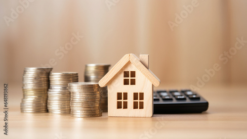 Model house and coins on the table in the morning. Loan and tax concept.