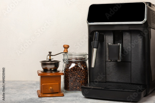 Modern coffee machine with a cup on the kitchen table. Coffee house. Modern espresso coffee machine with a cup in the kitchen. Preparation of a fragrant hot drink. Place for text.Copy space.