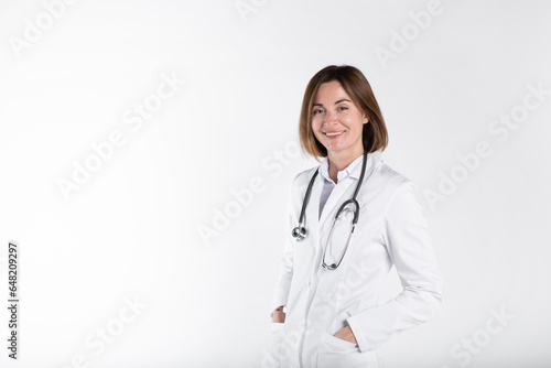 Young attractive female doctor standing and smiling isolated on white background 