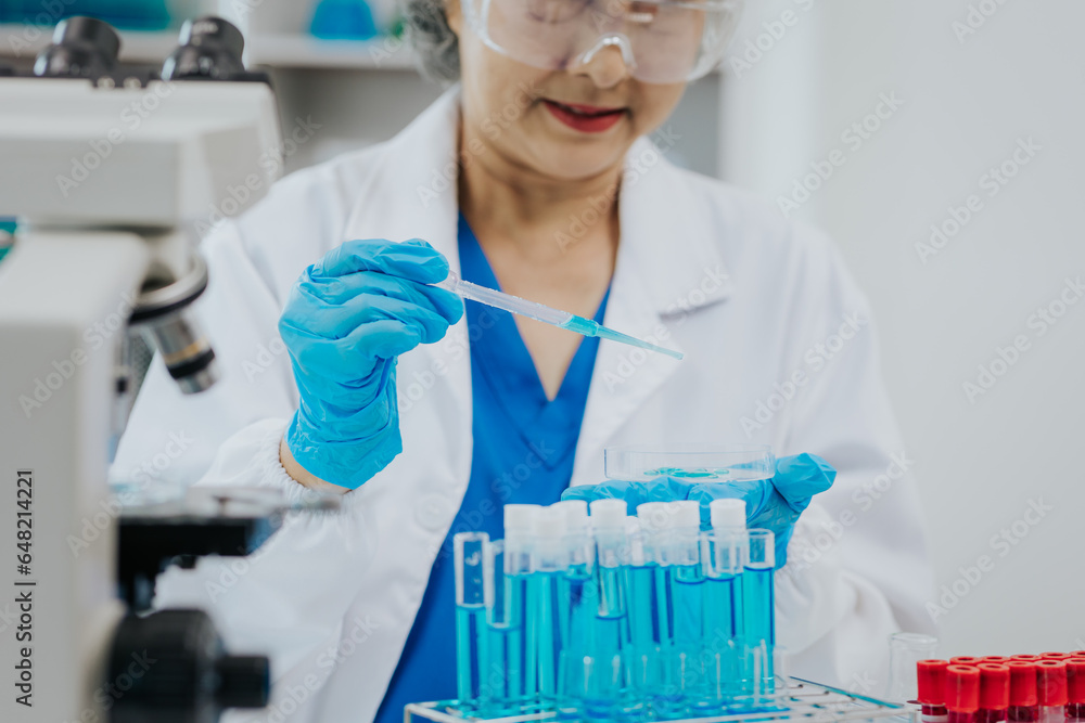 Two Asian scientists in the laboratory or medical personnel looking at a microscope in the lab Two Asian scientists in the laboratory or medical personnel looking at a microscope in the lab