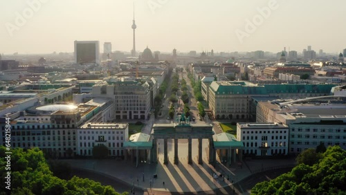 Establishing Aerial view of Berlin Skyline with Brandenburg City Gate. Main touristic landmarks of German capital as Symbolic travel destination. Scenic 4K drone zoom out wide shot photo