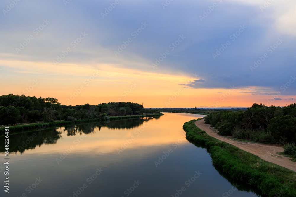 Fototapeta premium Colorful sunset over the water of the Canal du Rhone near Aigues-Mortes in Carmarque