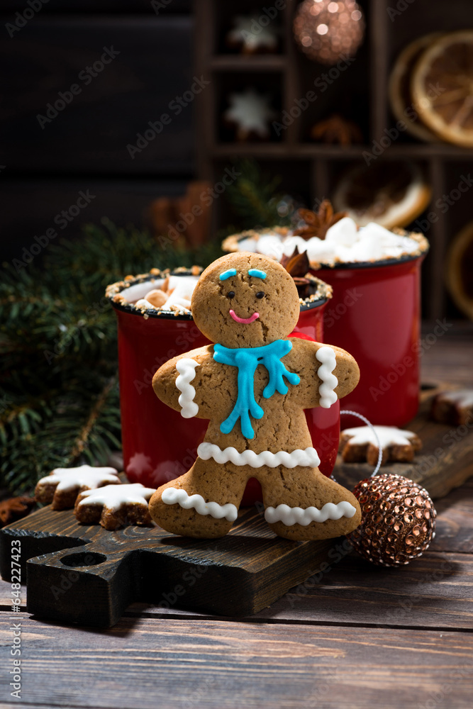 Fototapeta premium winter treats, gingerbread man cookies and hot chocolate on wooden table