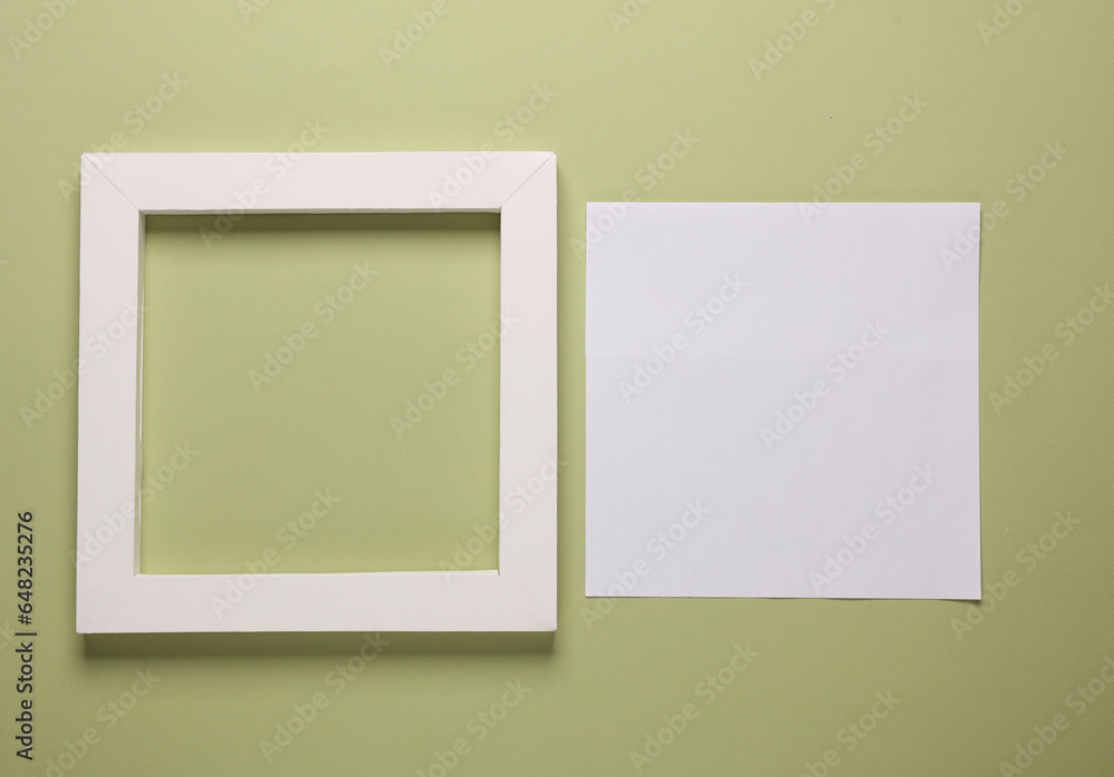 Blank square frame with white sheet of paper on green background Blank square frame with white sheet of paper on green background