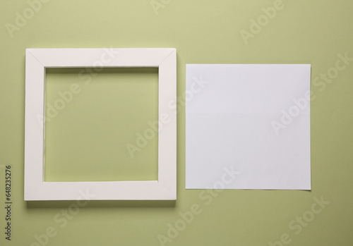 Blank square frame with white sheet of paper on green background