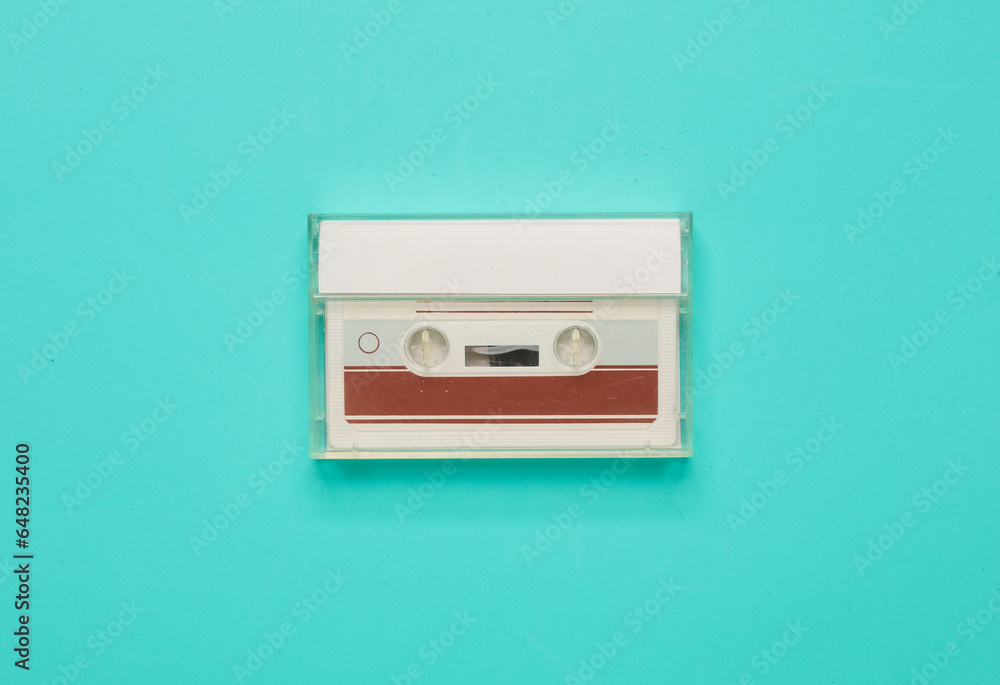 Fototapeta premium Retro 80s audio cassette in box on blue background. Music concept, vintage technology