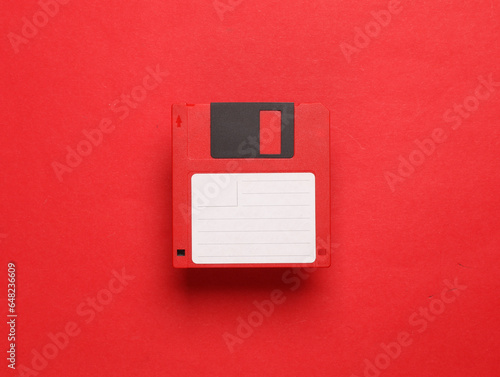 Fotografie Red floppy disk on a red background. Retro 80s