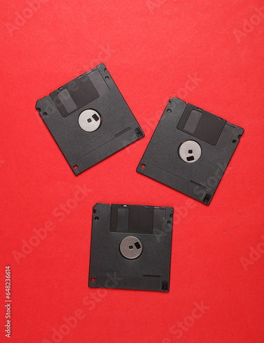 Black floppy disks on a red background. Retro 80s