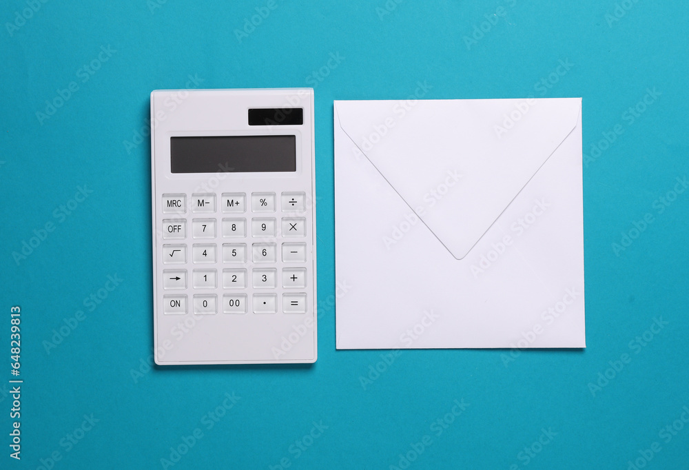 Calculator and envelope on blue background. Top view Calculator and envelope on blue background. Top view