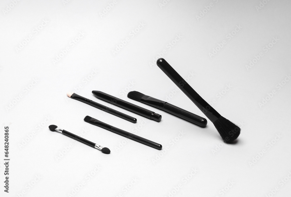 Black make-up brushes on a gray background Black make-up brushes on a gray background