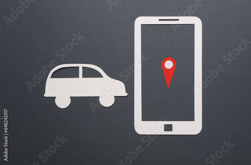 Paper cut smartphone icon with gps navigation point and car on gray background