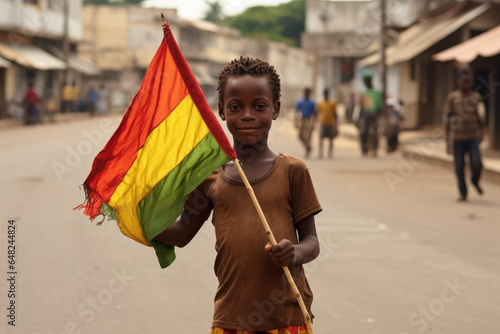 Un garçon guinéen tenant le drapeau de la Guinée dans les rues de Conakry
