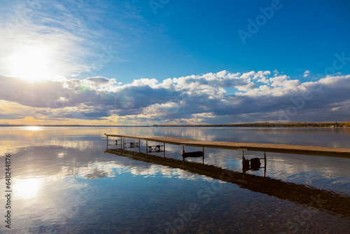 A Dock Leading Out Into The Lake At Sunrise; Pigeon Lake, Alberta, Canada