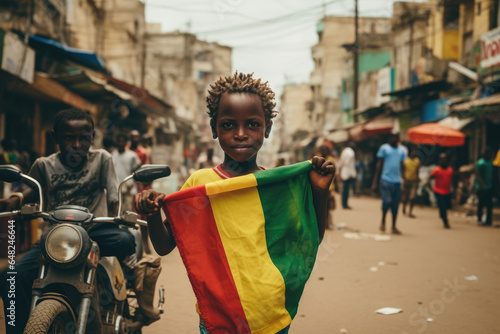 Un garçon guinéen tenant le drapeau de la Guinée dans les rues de Bamako photo