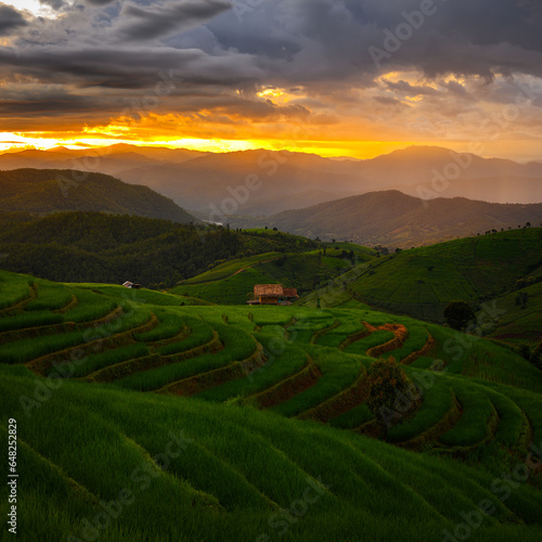 mountains landscape with bamboo hut on terraced green rice fields in cloudy day at sunset, pa pong pieng village, Mae chaem, Chiang mai