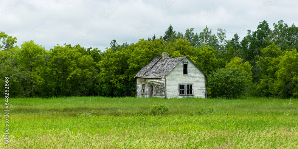 Old Wooden Farmhouse In A Grass Field; Silver, Manitoba, Canada Old Wooden Farmhouse In A Grass Field; Silver, Manitoba, Canada