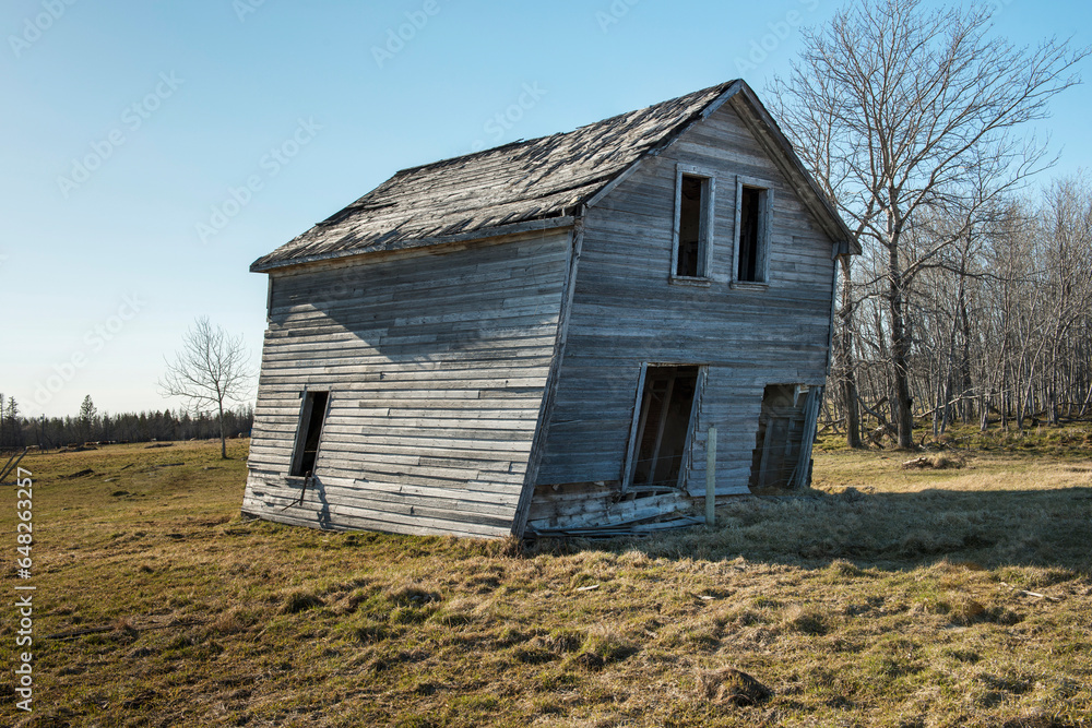 An Abandoned Wooden House Leaning To One Side; Manitoba, Canada An Abandoned Wooden House Leaning To One Side; Manitoba, Canada