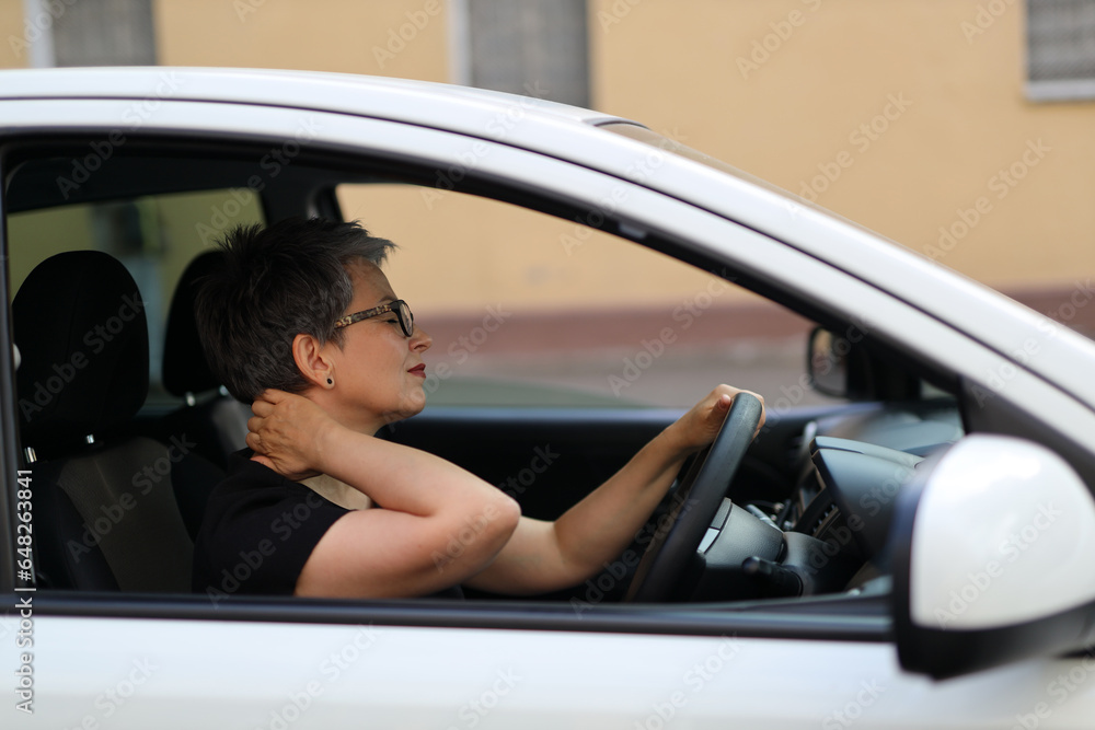 attractive mature and fashion-forward female driver relaxed in her car
