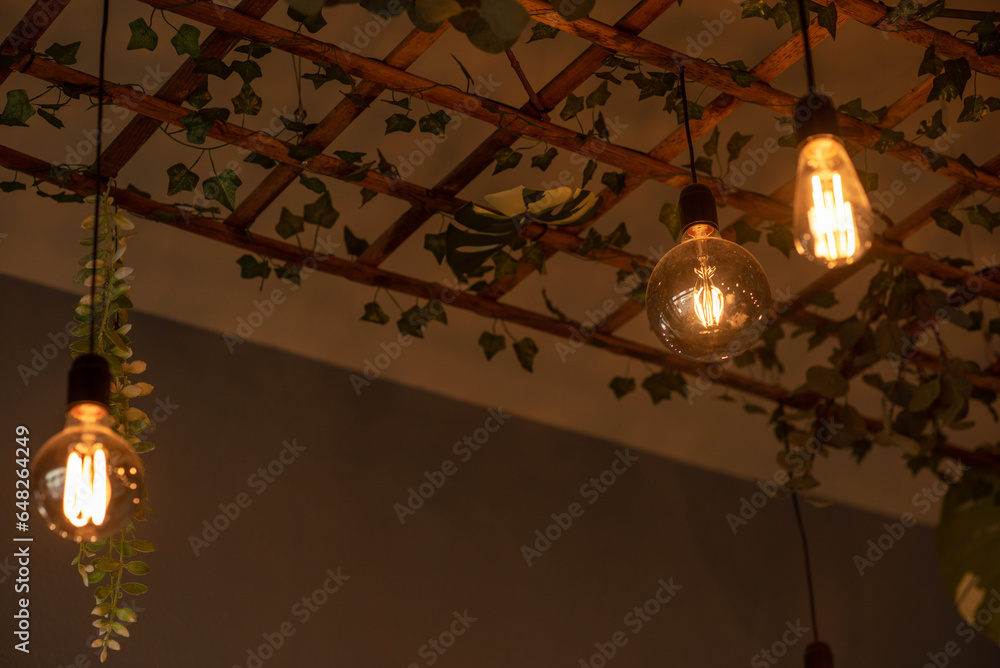 A modern lamp made of a wooden lattice, decorated with plants. Modern design