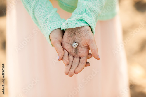 Child Holding a Sandy Seashell