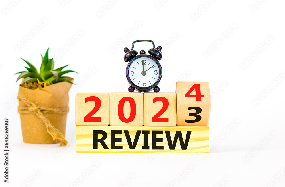 2024 review new year symbol. Businessman turns a wooden cube and