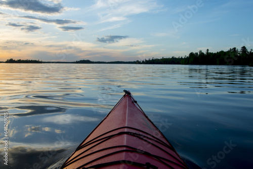 Bow Of A Canoe On A Tranquil Lake At Sunset; Ontario, Canada