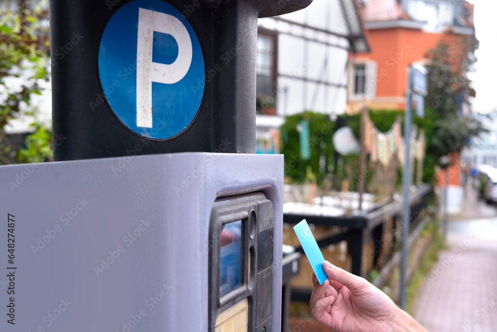 Φωτογραφία man pays with bank credit card for time of parking car in street parking meter w