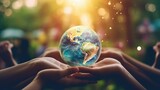 human hands gently cradling a globe against a blurred, lush blue nature background. The photo conveys the message of support for our planet.