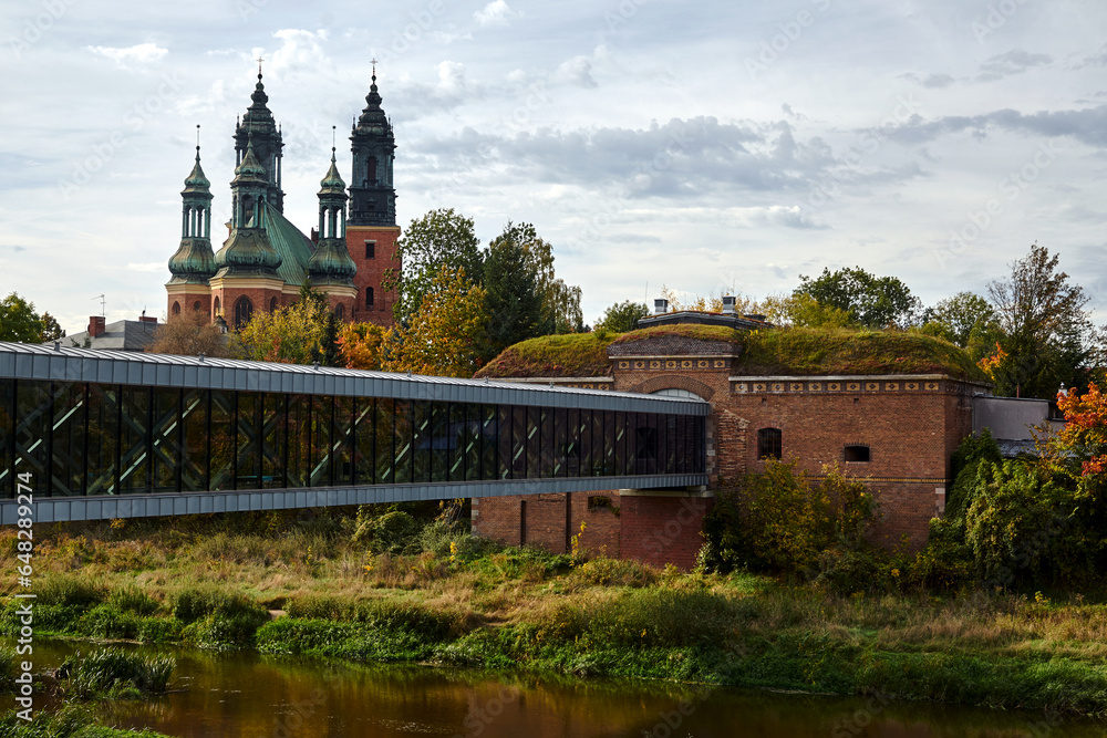 modern footbridge over the Warta River, Prussian fortifications and towers of the Gothic cathedral in Poznan
