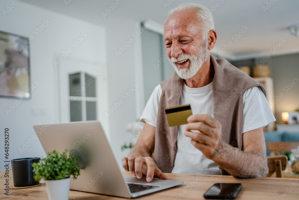 One senior man use laptop computer hold credit car shopping online One senior man use laptop computer hold credit car shopping online
