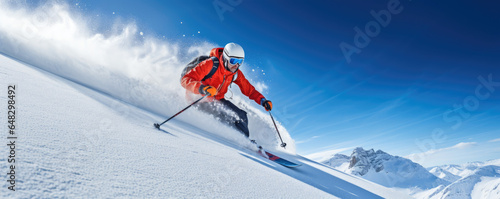 Skier carving down a powdery slope against a clear blue sky photo