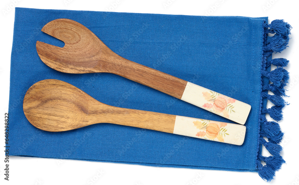 Two wooden spoons on a blue textile kitchen towel, top view