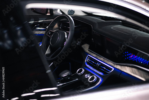 Car interior wood and leather decoration and blue ambient light © AvokadoStudio