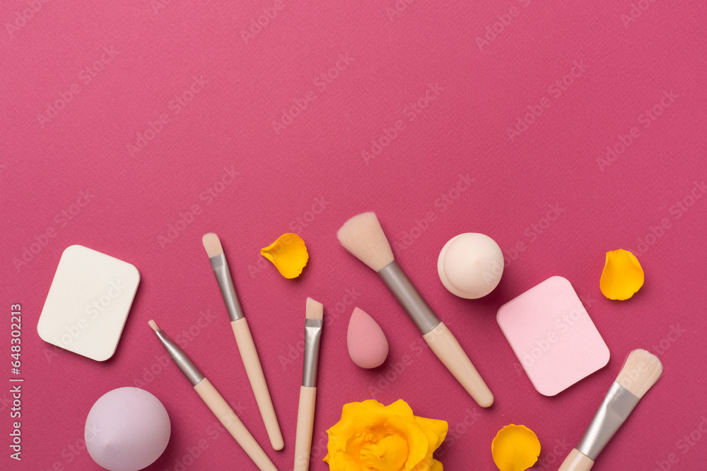 Makeup brushes and sponges on color background, top view Makeup brushes and sponges on color background, top view