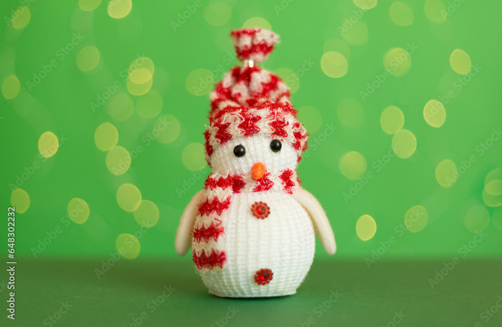 Fototapeta premium Cute snowman on table against blurred lights
