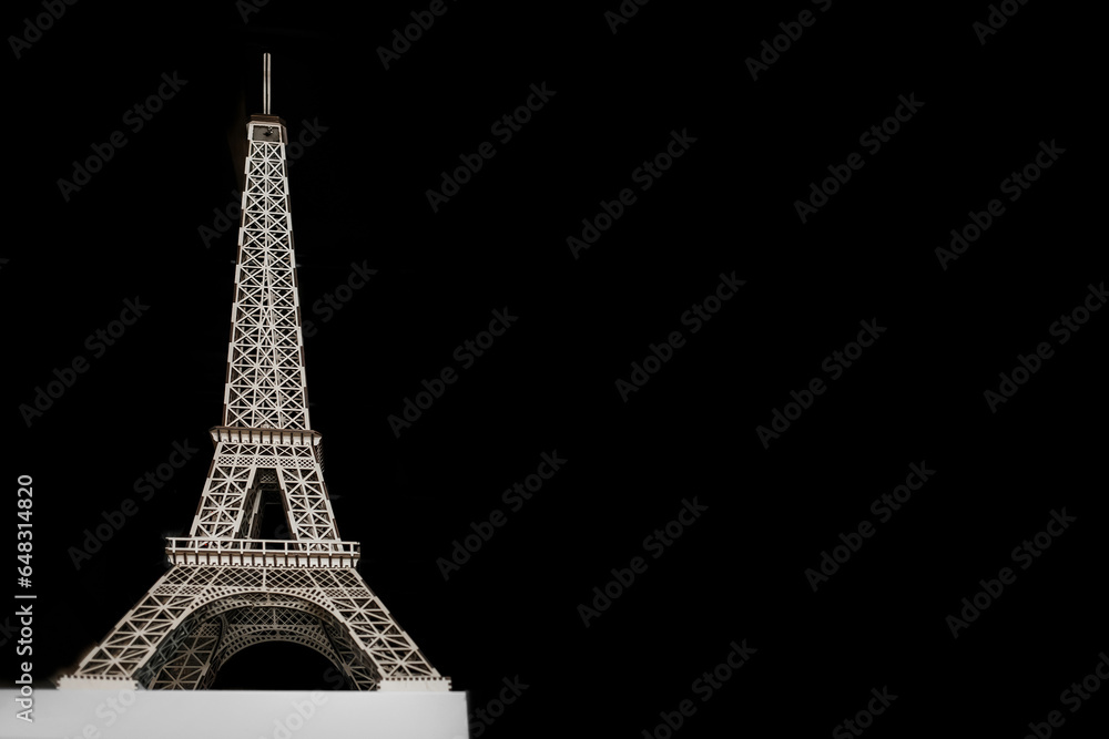Eiffel Tower object toy shape made of wood on a black background copy space