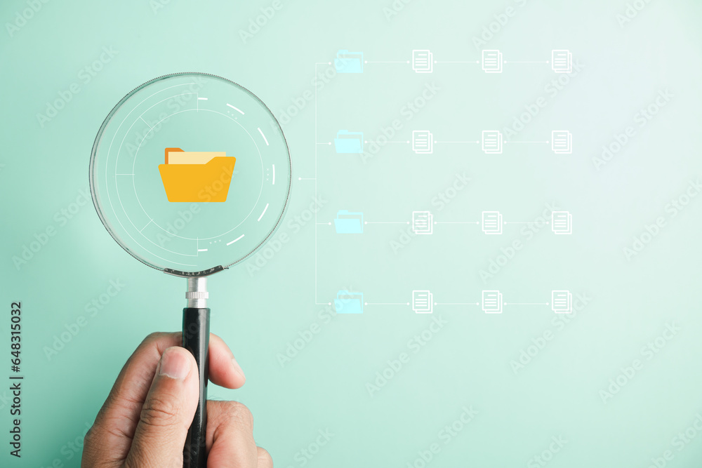 Conceptual image of a hand holding a magnifying glass, conducting a ...