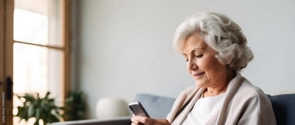 The elderly woman is sitting on the couch to drink coffee and look at her phone The elderly woman is sitting on the couch to drink coffee and look at her phone