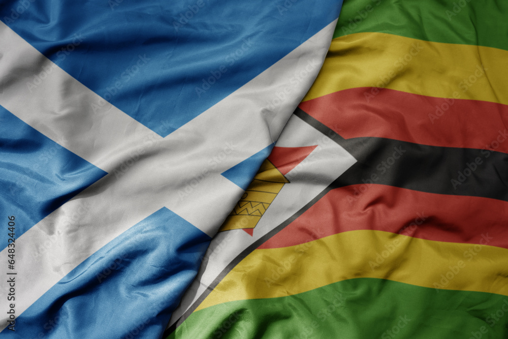big waving national colorful flag of scotland and national flag of zimbabwe .