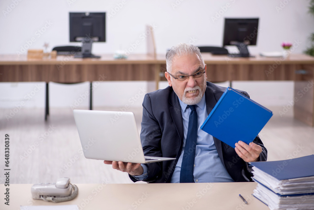 Old male employee working in the office Old male employee working in the office