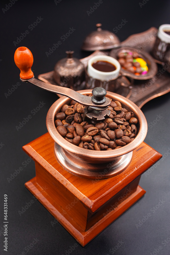 Nostalgic coffee grinder, artistically designed squirrel and tray, cooked Turkish coffee, sweets. Photograph.