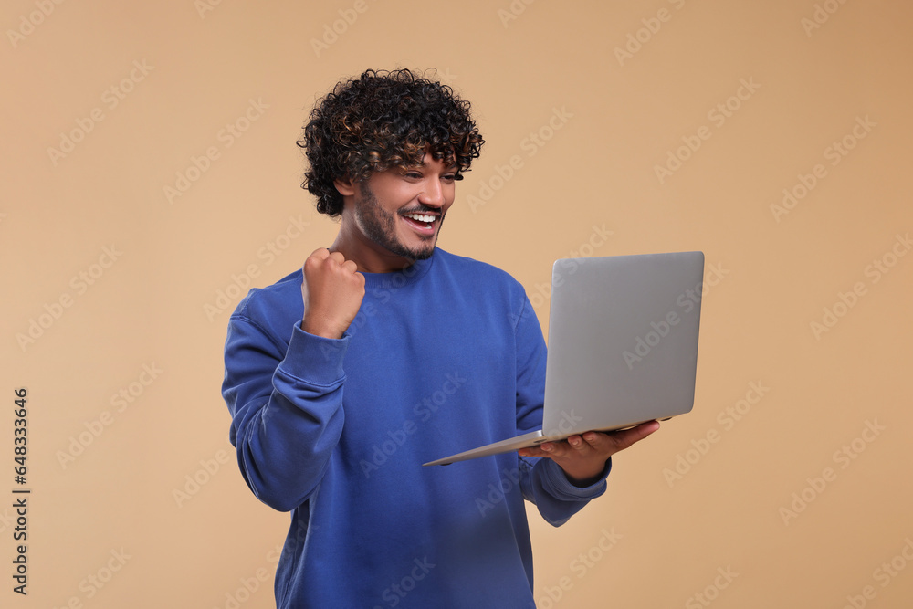 Smiling man with laptop on beige background Smiling man with laptop on beige background