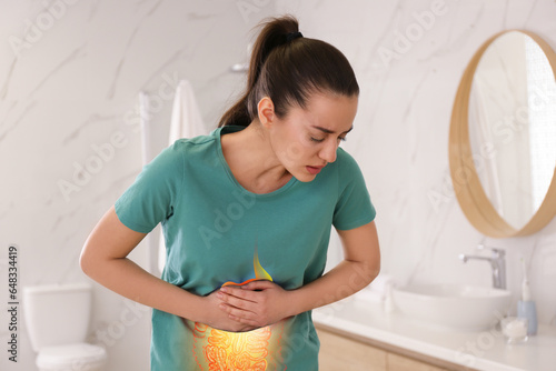 Healthcare service and treatment. Woman suffering from abdominal pain in bathroom. Illustration of gastrointestinal tract photo