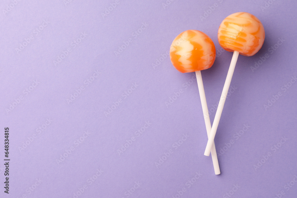 Tasty lollipops on violet background, flat lay. Space for text Tasty lollipops on violet background, flat lay. Space for text