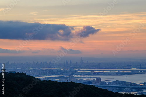 夜明け前のオレンジ色に染まる空と湾岸。神戸市の高台から大阪湾と大阪南港をのぞむ。