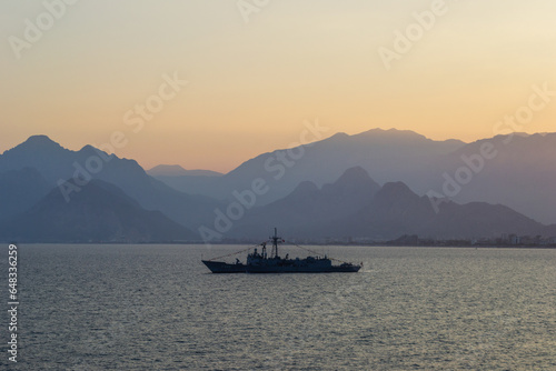 Turkey military warship on sunset with mountains on the background © SKOSOPASKA