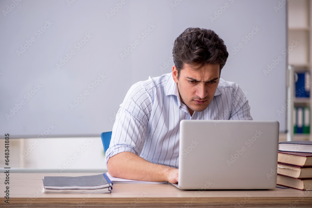 Young male teacher in front of white board Young male teacher in front of white board
