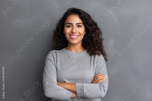 A confident woman with a friendly smile and crossed arms