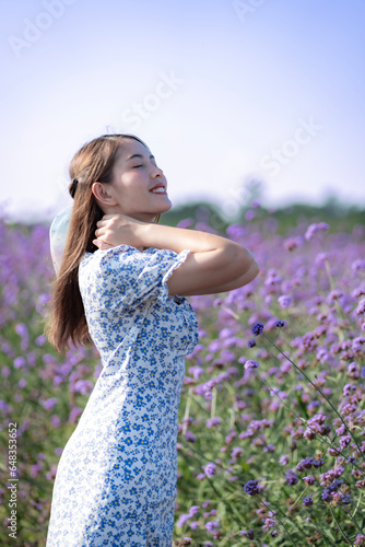 Portrait of a cheerful Asian Thai woman in a purple flower garden.
